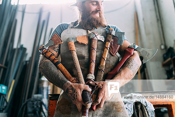 Axe maker showing off variety of handcrafted axes