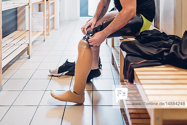 Mann mit Beinprothese im Umkleideraum der Turnhalle