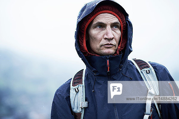 Männlicher Wanderer mit Kapuzenanorak bei Regen  Manigod  Rhône-Alpes  Frankreich