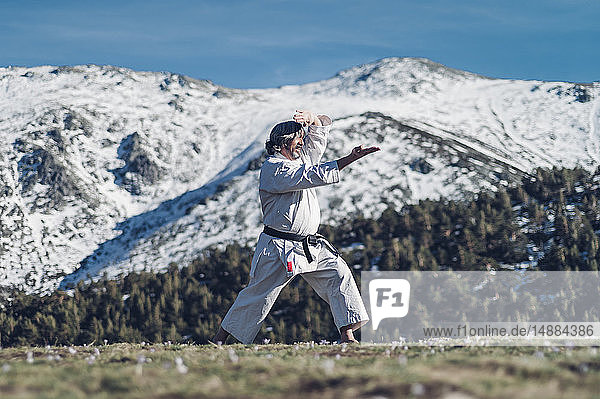 Älterer Mann praktiziert Karate im Freien