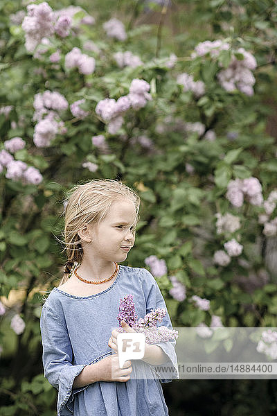 Portrait of smiling girl with lilac blossoms