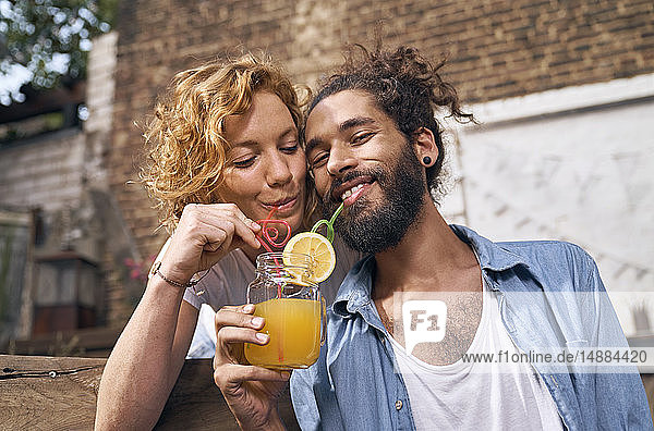 Junges Paar trinkt kühle Limonade in einem Hinterhof