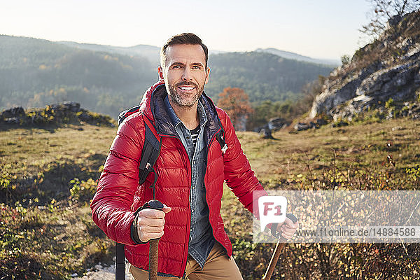 Porträt eines lächelnden Mannes auf einer Wanderung in den Bergen