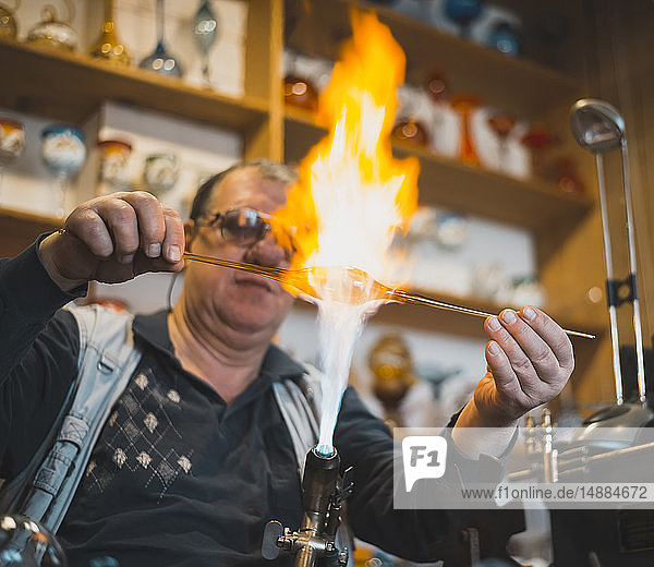 Glass blower forming melting glass