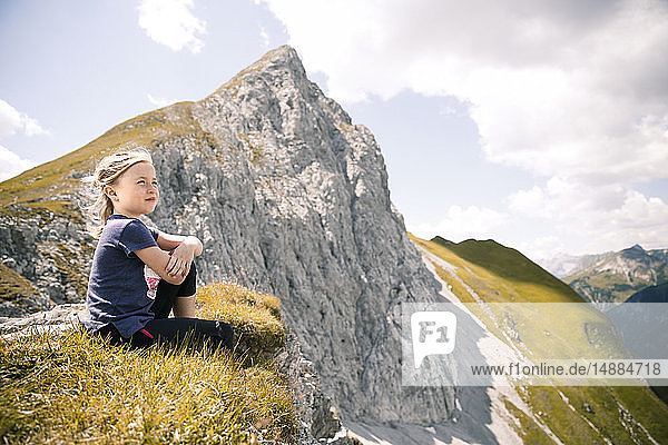 Österreich  Tirol  Mädchen in Berglandschaft sitzend