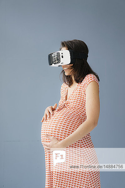 Frau  die vorgibt  schwanger zu sein  mit VR-Brille