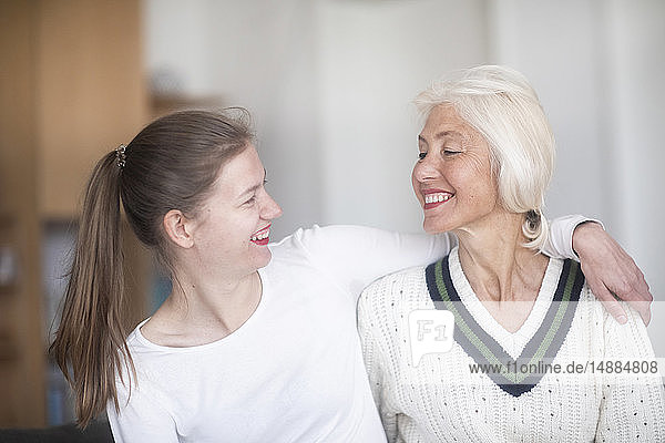 Smiling mother and adult daughter looking at each other