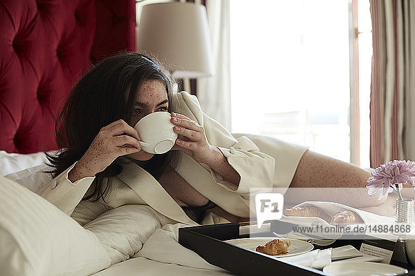 Teenage girl having breakfast in bed