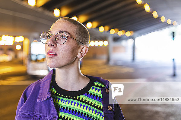 Porträt einer jungen Frau in der Stadt neben einer U-Bahn-Kreuzung