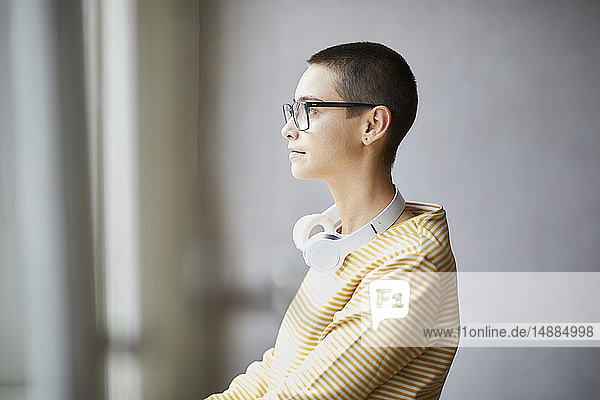 Porträt einer kurzhaarigen jungen Frau mit Brille und Kopfhörer