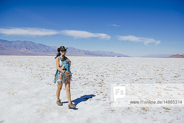 USA  California  Death Valley National Park  Badwater Basin  happy mother walking with baby girl in salt basin
