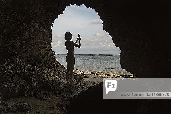Young woman in cave  taking a photo