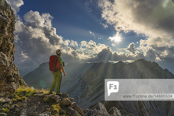 Italy  Veneto  Dolomites  Alta Via Bepi Zac  mountaineer standing on Costabella mountain at sunset
