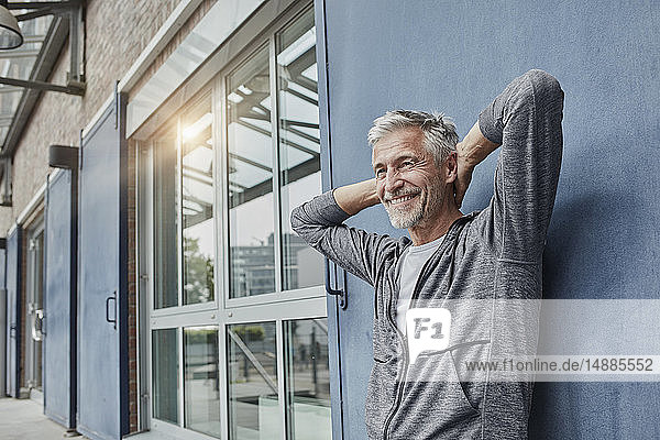 Portrait of laughing mature man in front of gym
