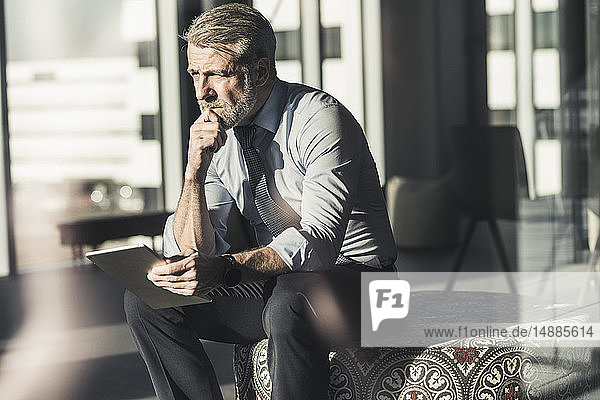 Mature businessman using tablet in office