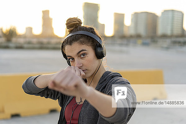 Sportive young woman with headphones during workout  boxing