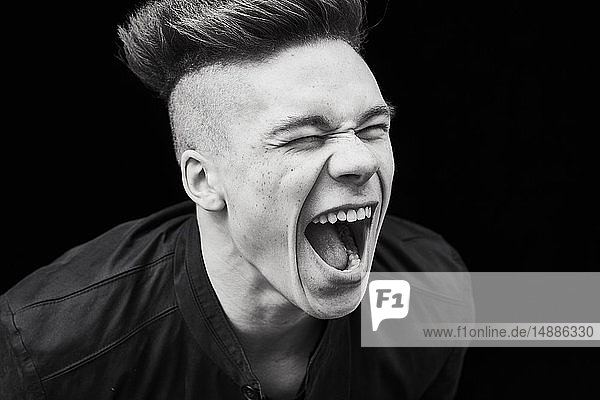 Black and white portrait of young man screaming
