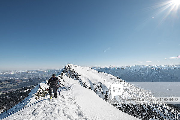 Germany Bavaria Gamsknogel Weissbach Chiemgau senior man hiking in winter landscape