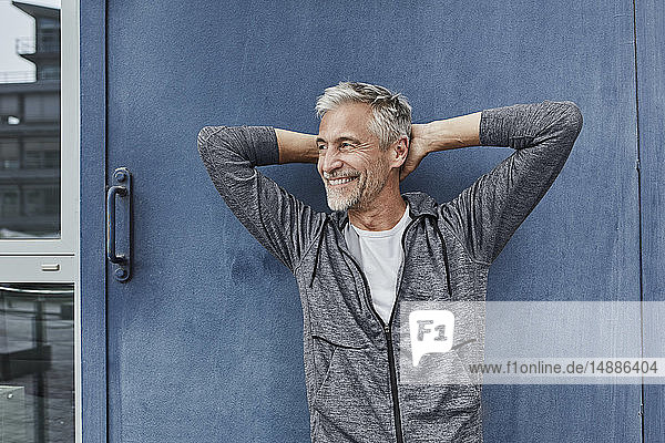 Porträt eines lachenden  reifen Mannes vor der Turnhalle