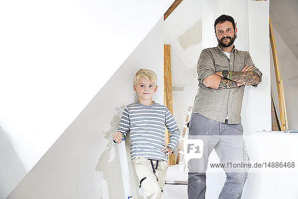 Porträt eines selbstbewussten Vaters und Sohnes bei der Dachbodenumrüstung
