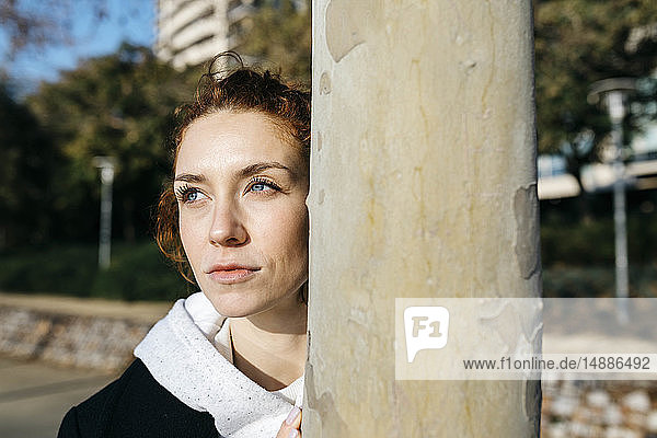 Portrait of pensive young woman at a tree