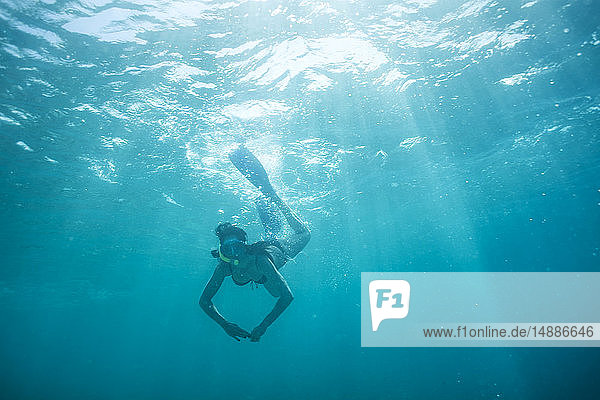 Frau mit Flossen und Schnorcheltauchen unter Wasser