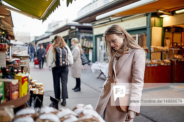 Austria  Vienna  woman looking at offer at Naschmarkt