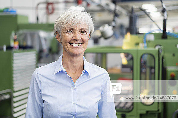 Porträt einer lächelnden älteren Geschäftsfrau in einer Fabrik