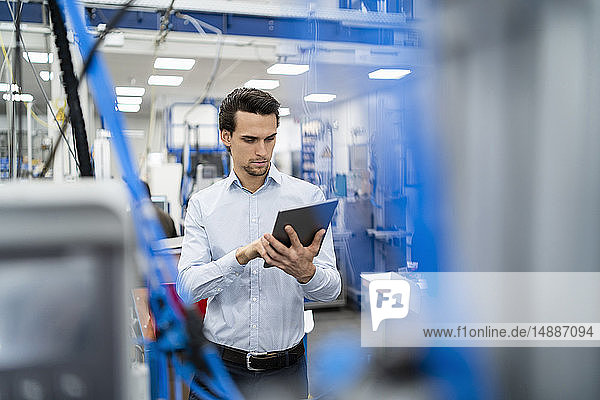 Businessman using tablet in a factory