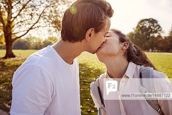 Junges verliebtes Paar küsst sich in einem Park