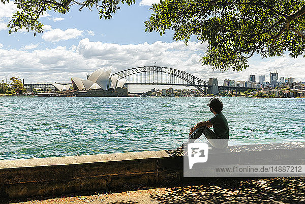 Australien  New South Wales  Sydney  Mann schaut auf die Brücke und das Opernhaus von Sydney