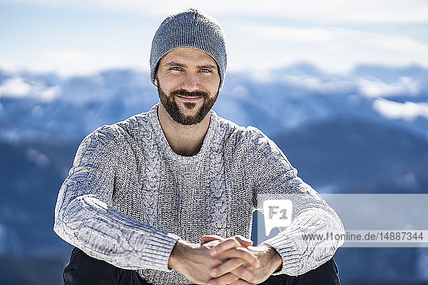 Deutschland  Bayern  Brauneck  Porträt eines lächelnden Mannes im Winter in den Bergen