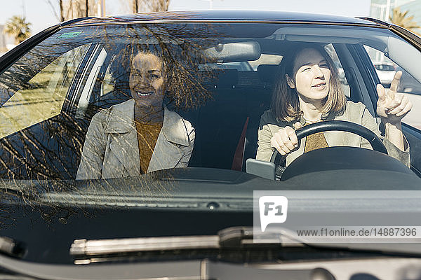 Zwei Frauen fahren in einem Auto durch die Stadt