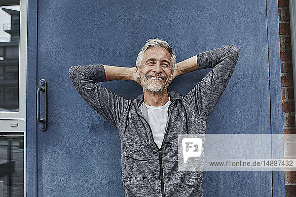Porträt eines lachenden  reifen Mannes vor der Turnhalle