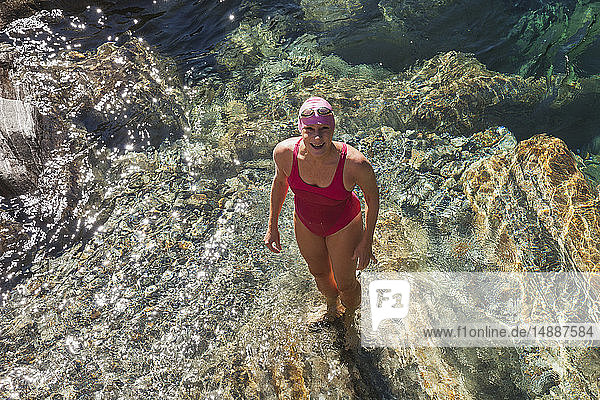 Switzerland  Ticino  Verzasca Valley  portrait of happy woman in swimsuit standing in Verszasca river