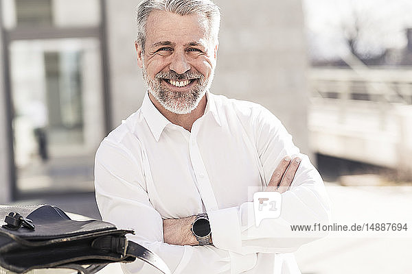 Porträt eines lächelnden selbstbewussten reifen Geschäftsmannes im Freien