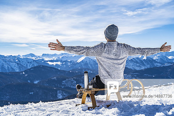 Deutschland  Bayern  Brauneck  fröhlicher Mann im Winter in den Bergen bei einer Pause