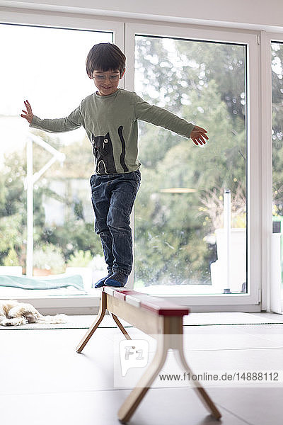 Kleiner Junge  der auf einem Balken balanciert