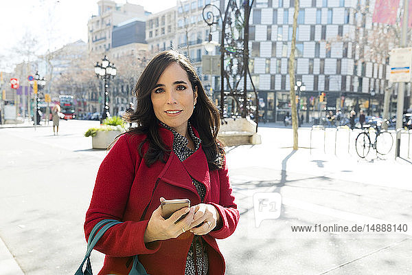 Porträt einer Frau mit Handy in der Stadt