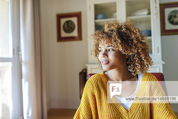Junge Frau mit lockigem Haar zu Hause