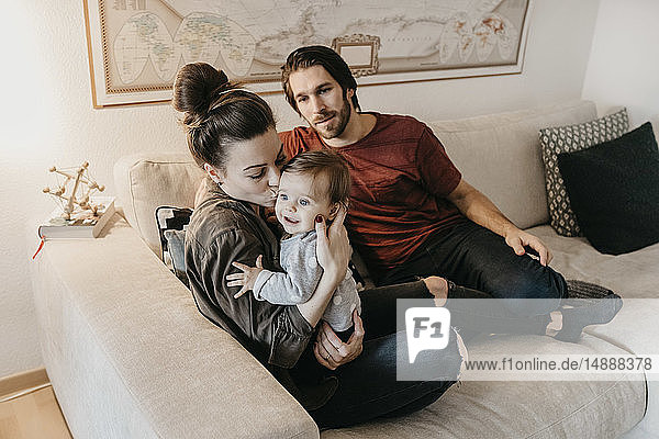 Happy family with baby girl in living room at home