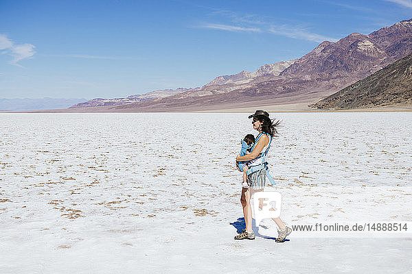 USA  California  Death Valley National Park  Badwater Basin  mother walking with baby girl in salt basin