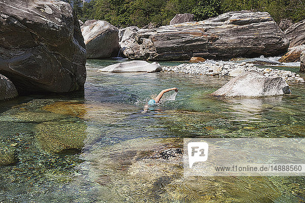 Schweiz  Tessin  Verzascatal  Frau schwimmt im erfrischenden Fluss Verszasca