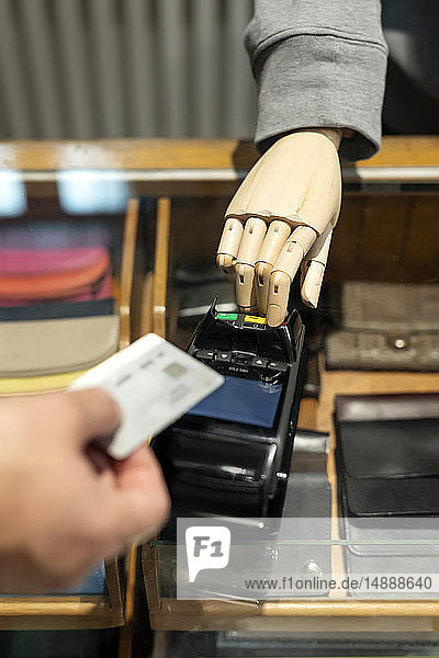Kunde bezahlt mit Kreditkarte  Roboter assistiert