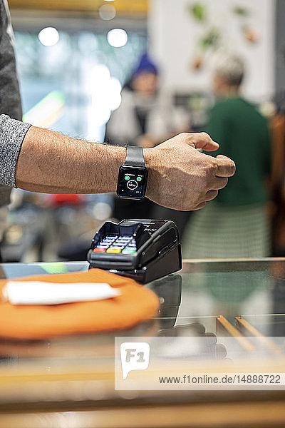 Customer paying contactless with his smartwatch