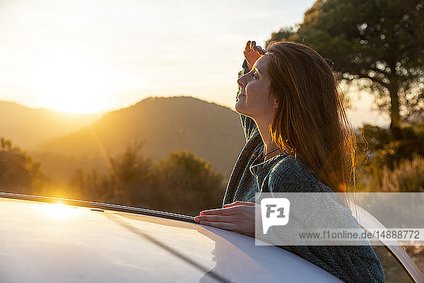 Junge Frau auf einer Autoreise macht eine Pause schützt die Augen