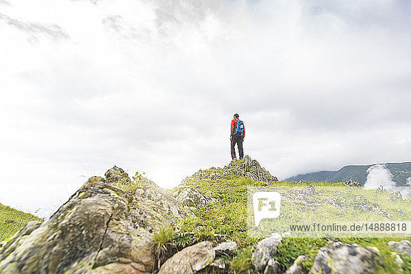 Mann  der auf einem Hügel steht und die Landschaft in den Karpaten betrachtet  Rumänien