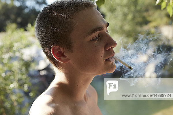 Porträt eines zigarettenrauchenden Teenagers in der Natur