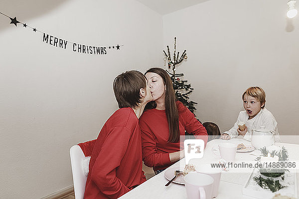 Gleichgeschlechtliche Familie feiert Weihnachten zu Hause  Frauen küssen