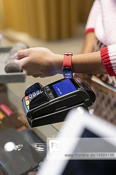Customer paying contactless with her smartwatch